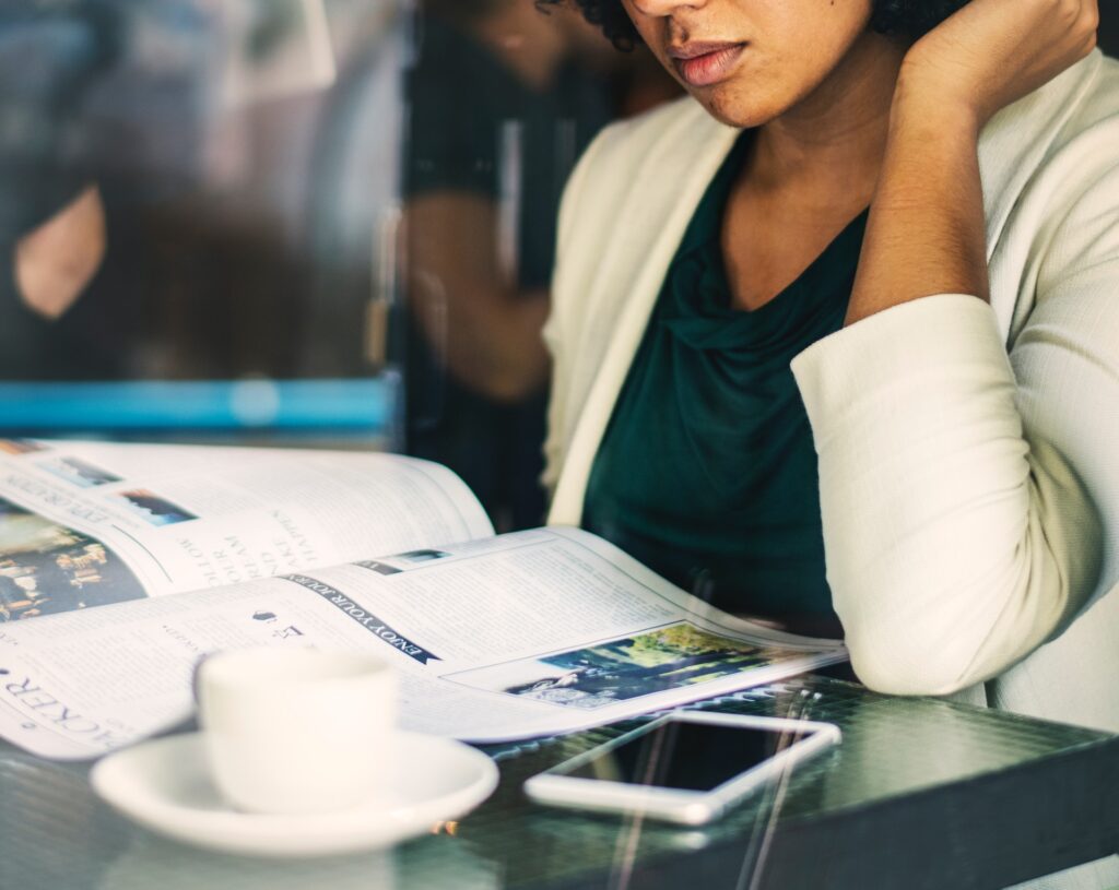 A woman reading a newspaper. Another proven practice is to teach current events and controversial issues.