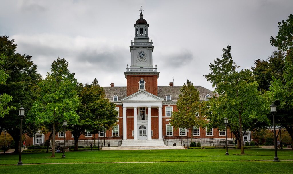 A typical college hall, behind trees. Should colleges require civics courses for graduation?