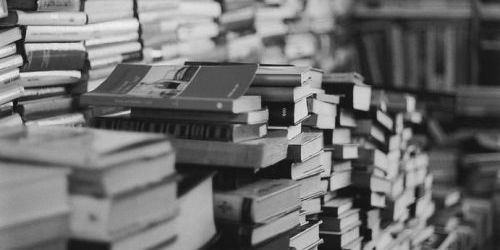 Pile of old books with one in focus and the rest blurred.