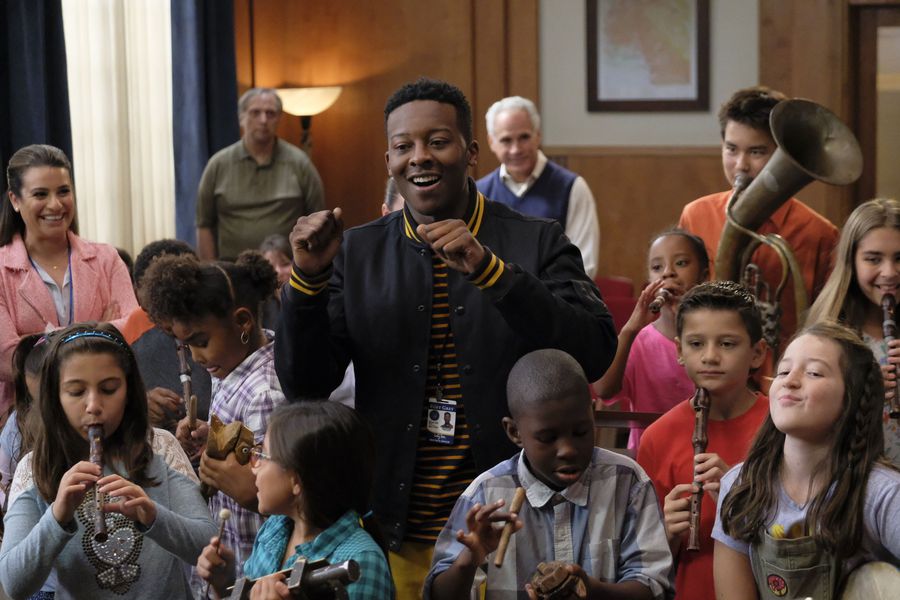 Mayor Courtney Rose amongst a group of children playing music at a City Council meeting.