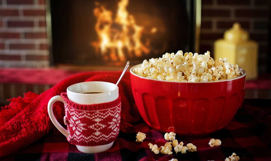 Popcorn and Hot Chocolate on a table in front of a Fireplace