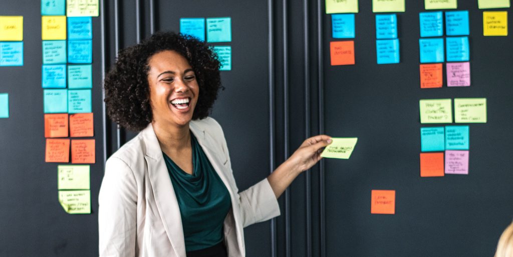 Two women have a discussion about sticky notes, organized around essential questions and themes.