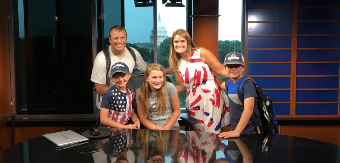 C-SPAN Teacher Fellow Sunshine, with her family, posing for a picture in one of C-SPAN's studios.